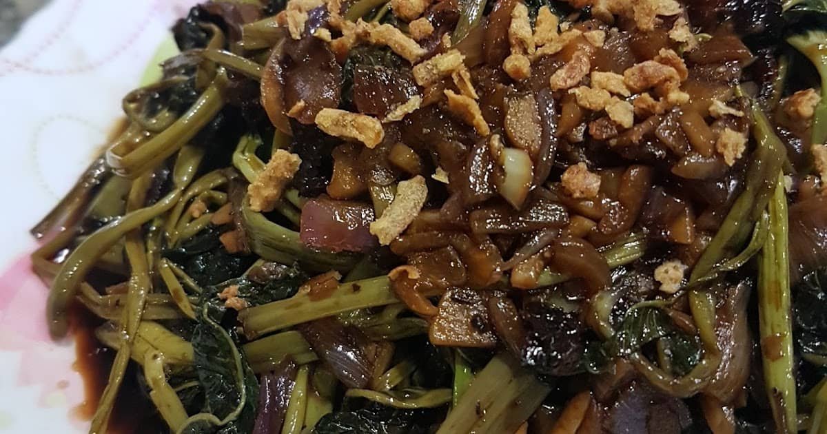 The image showcases Adobong Kangkong, a popular Filipino dish made from water spinach sautéed in soy sauce, vinegar, garlic, and onions. The dish is garnished with crispy fried garlic bits, adding texture to the savory flavors.