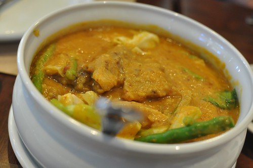 A bowl of Beef and Balut Kare Kare with vegetables in a rich peanut sauce.
