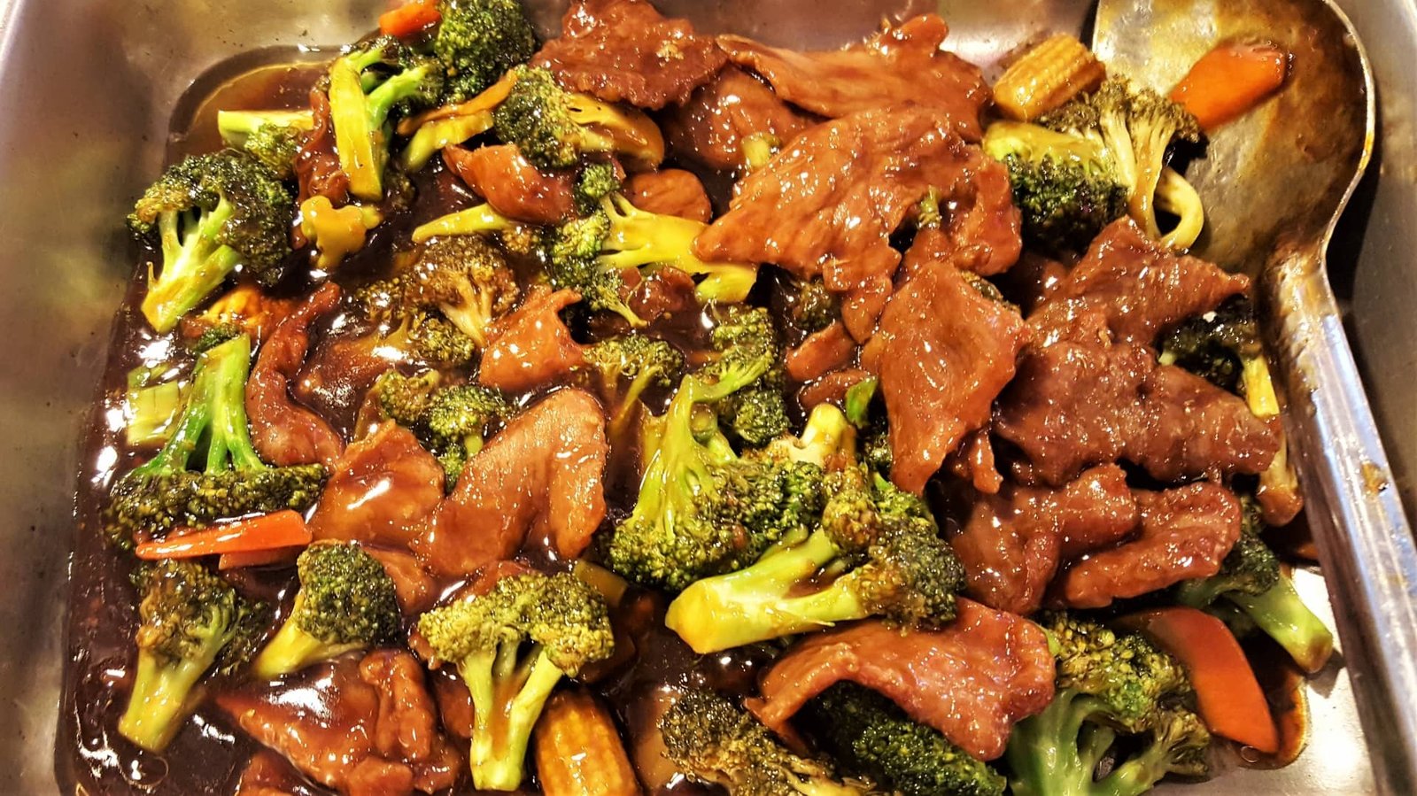 Beef and broccoli in a rich oyster sauce served in a pan.