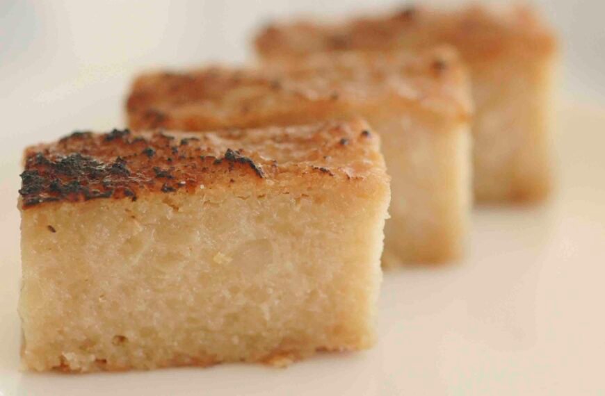 Three pieces of Cassava Pudding, each with a golden-brown crust and a dense, moist interior. The pudding has a slightly caramelized top, adding a rich texture and flavor to this traditional Filipino dessert.