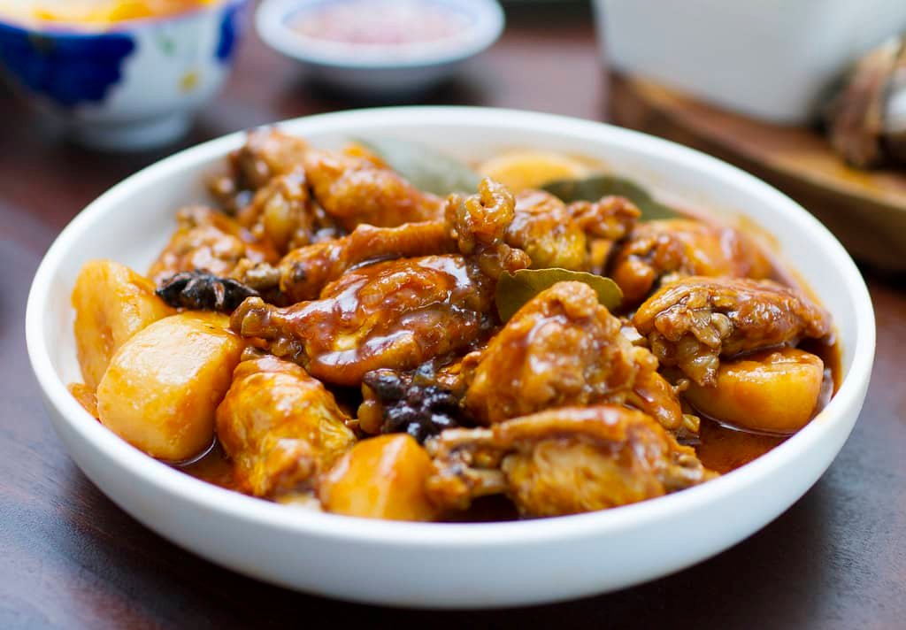 A bowl of flavorful Chicken Asado, featuring tender chicken pieces and potatoes simmered in a rich, savory sauce, highlighting the bold flavors of this traditional Filipino Chicken Asado recipe.