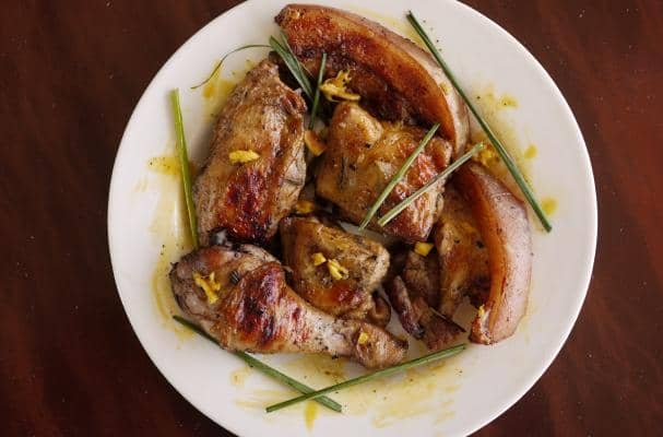 A plate of grilled Filipino Chicken Inasal garnished with green onions.
