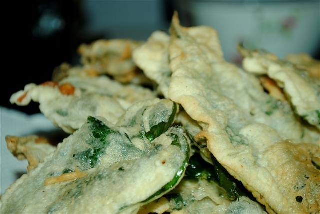 Crispy Kangkong, a popular Filipino snack made from deep-fried water spinach leaves coated in a light batter, golden brown and crunchy, served as an appetizer or side dish.