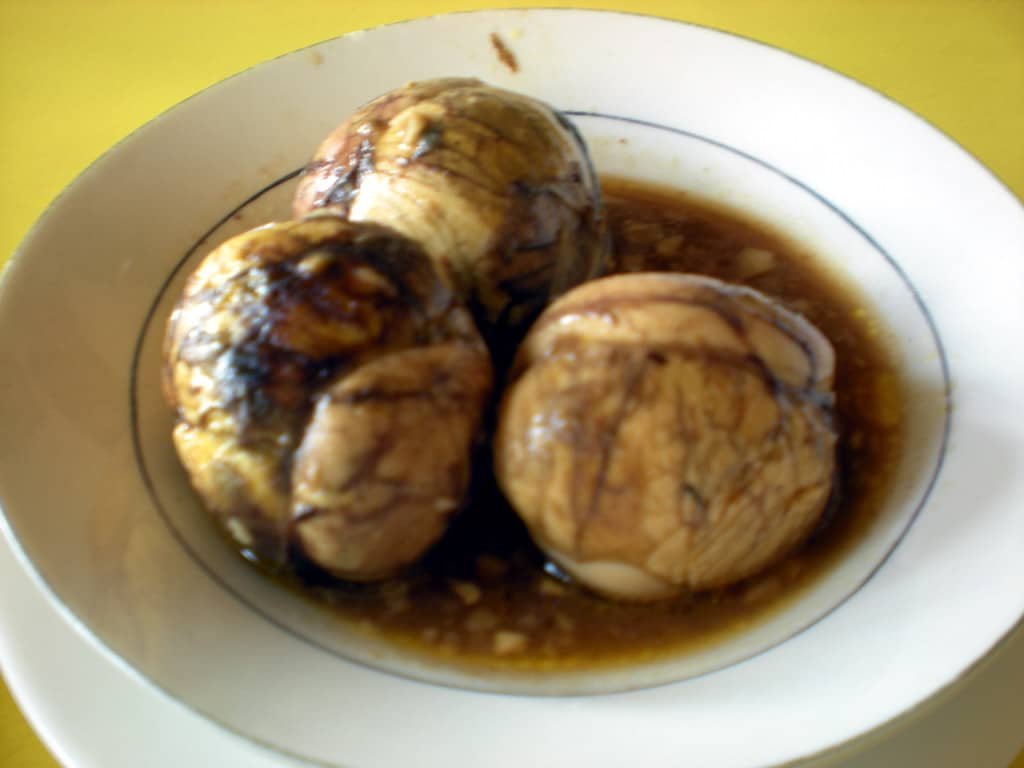 A plate of Egg Adobo (Adobong Itlog), featuring hard-boiled eggs soaked in a savory soy and vinegar sauce, served in a white dish, highlighting the rich flavors of this Filipino Adobong Itlog recipe.