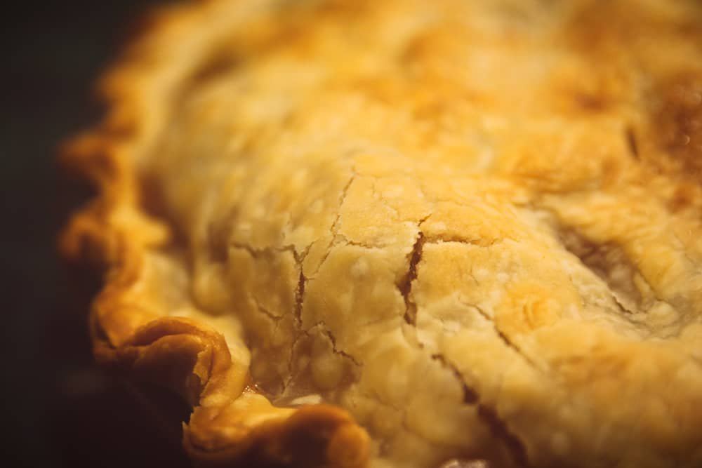 A close-up view of a golden, flaky Filipino egg pie, showcasing its perfectly baked crust with intricate cracks, ideal for a delicious Filipino egg pie recipe