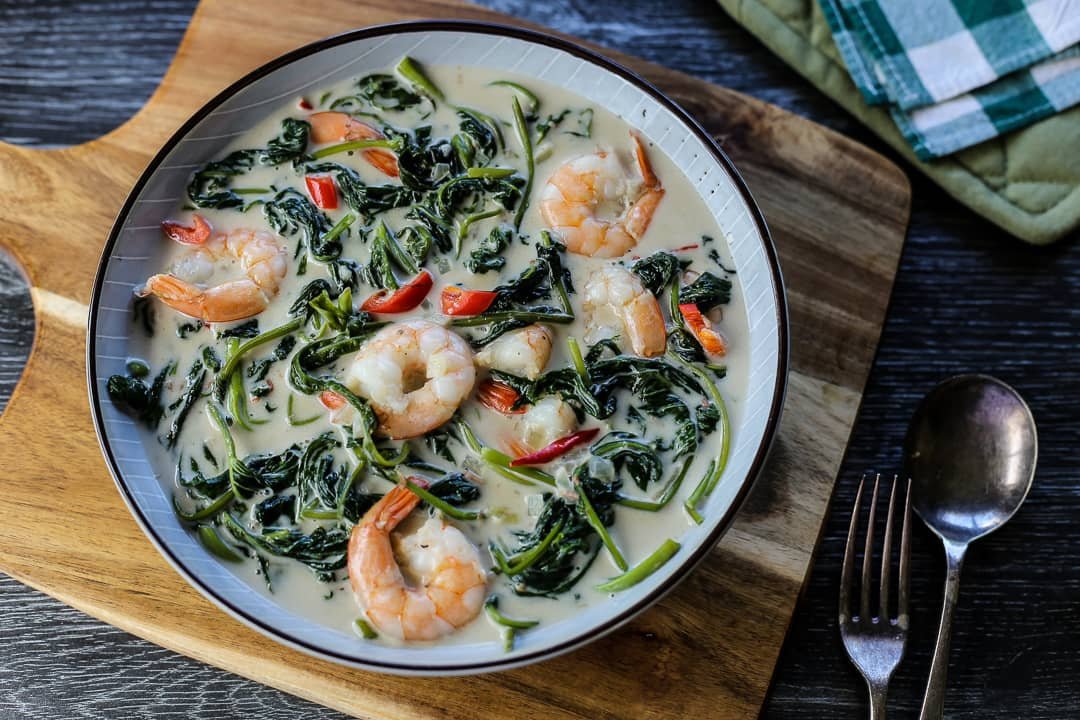 Ginataang Pinipig Recipe served in a bowl with shrimp, spinach, and red peppers in a rich coconut milk sauce.