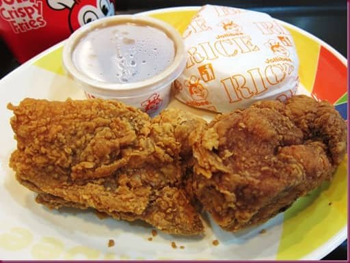 Two pieces of crispy Jollibee-style fried chicken served with rice and gravy.