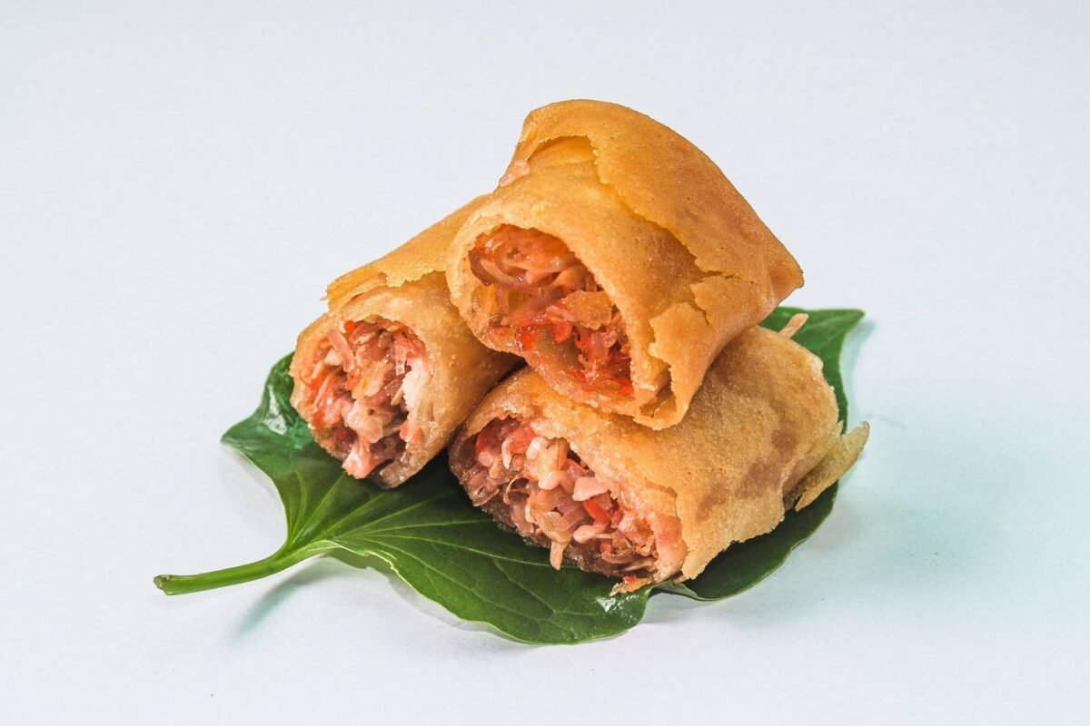 The image shows Peanut Tikoy Roll, a Filipino dessert made of sticky rice cake (tikoy) wrapped around a sweet peanut filling. The rolls are typically deep-fried, resulting in a golden and crispy exterior with a chewy, sweet, and nutty interior.