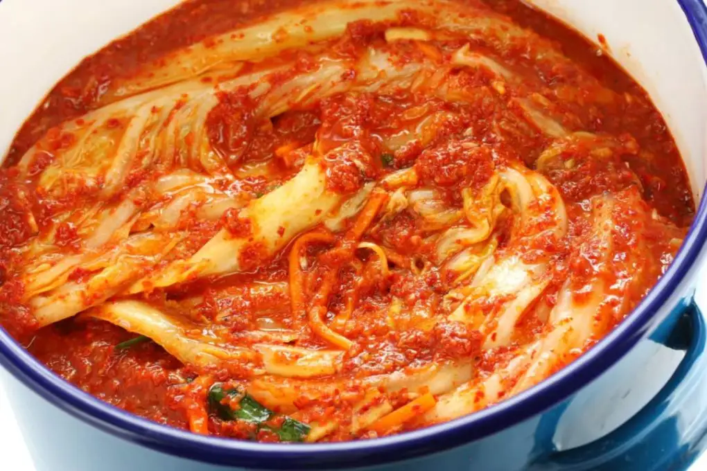 A bowl of vibrant and spicy Pechay Baguio Kimchi, featuring crisp napa cabbage covered in a rich, flavorful red chili paste.