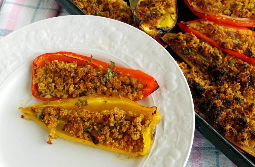 Stuffed bell peppers with a crumbly topping on a white plate.