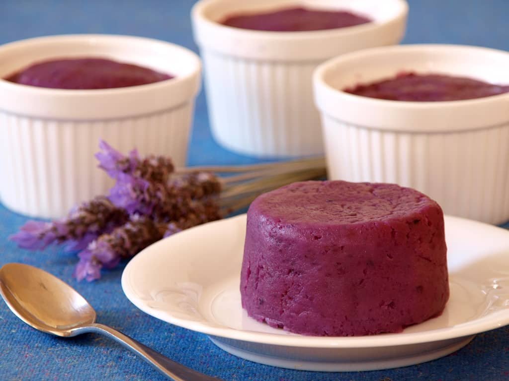 Ube Halaya, a smooth and creamy Filipino purple yam dessert, served in ramekins and plated, with a garnish of lavender on the side.